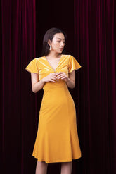 Velvet midi dress with flutter sleeves, pearl button detail, and figure-enhancing silhouette